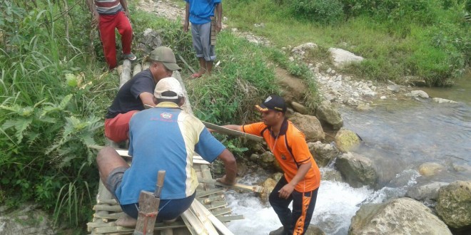 Bripka Jecky Amalo Gotong Royong Bersama Warga Membuat Jembatan Darurat